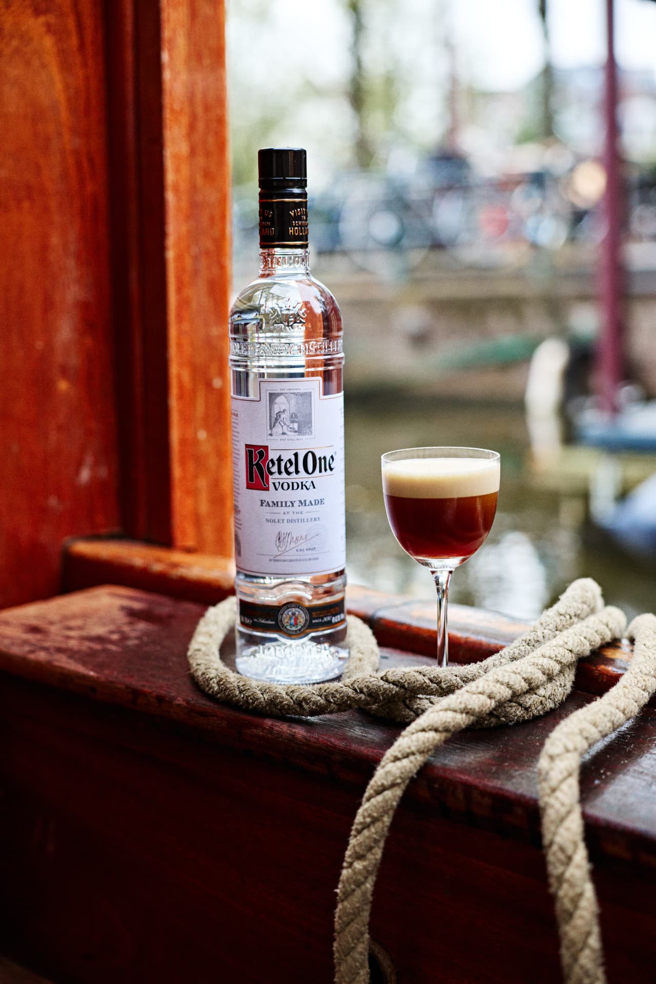 Ketel One bottle and cocktail beside a rope at the window