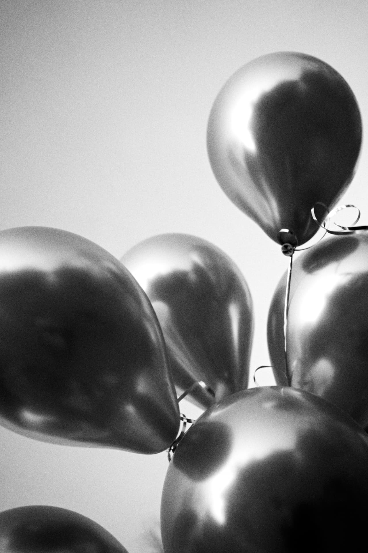 Balloons in black and white against a plain sky