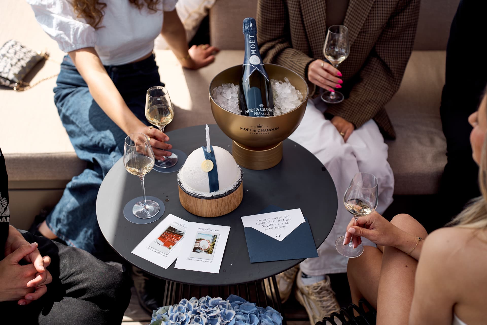 Table with the Pharrell bottle, cake and cards