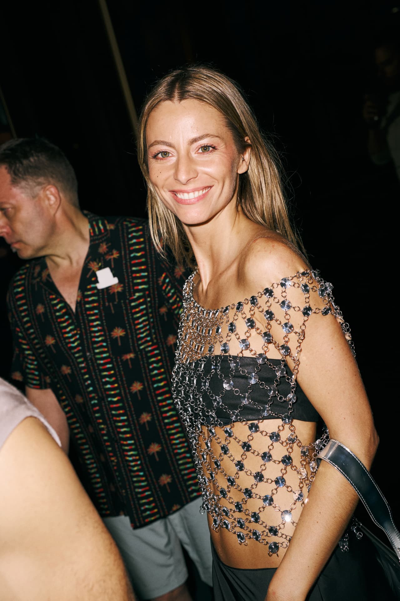 Guest smiling in an off the shoulder chainmail top