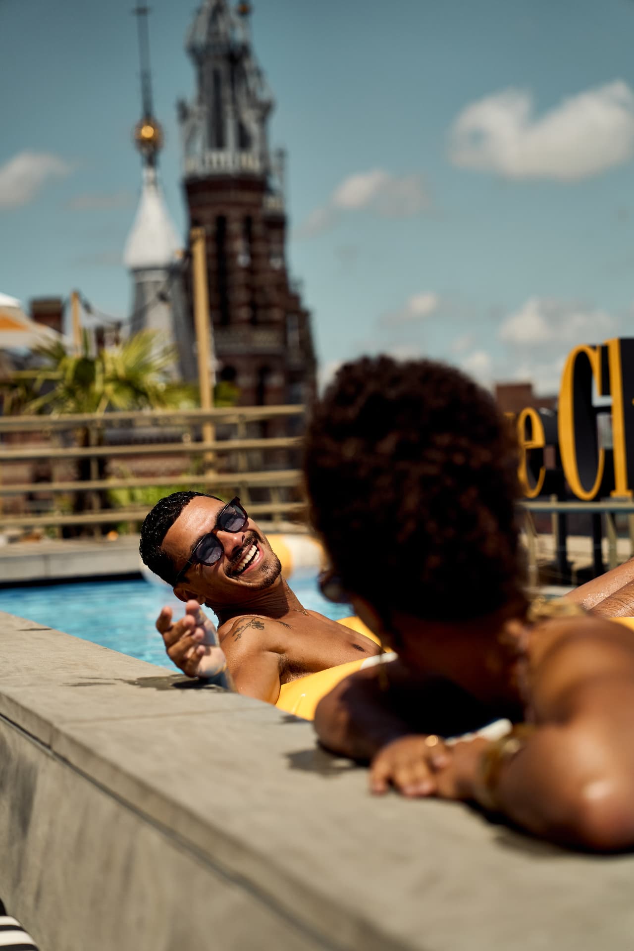 Two guests laughing at the pool edge