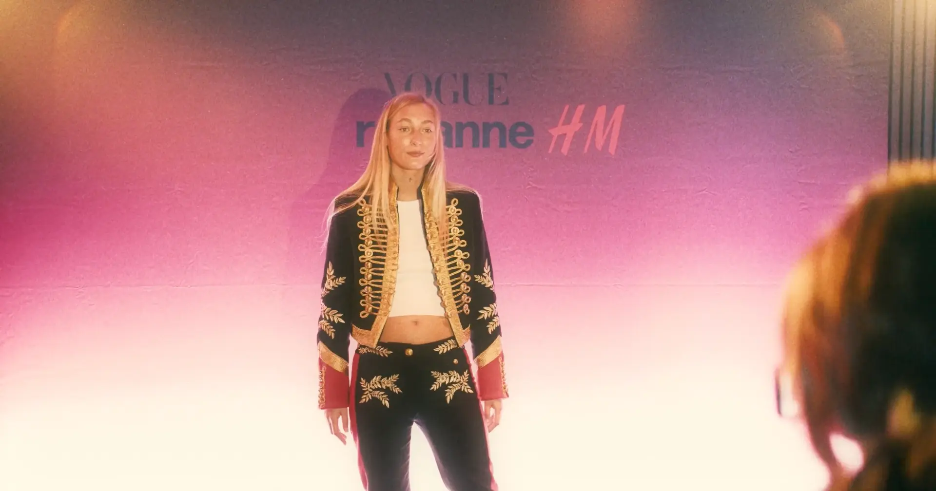 Guest in a patterned outfit against the illuminated event backdrop