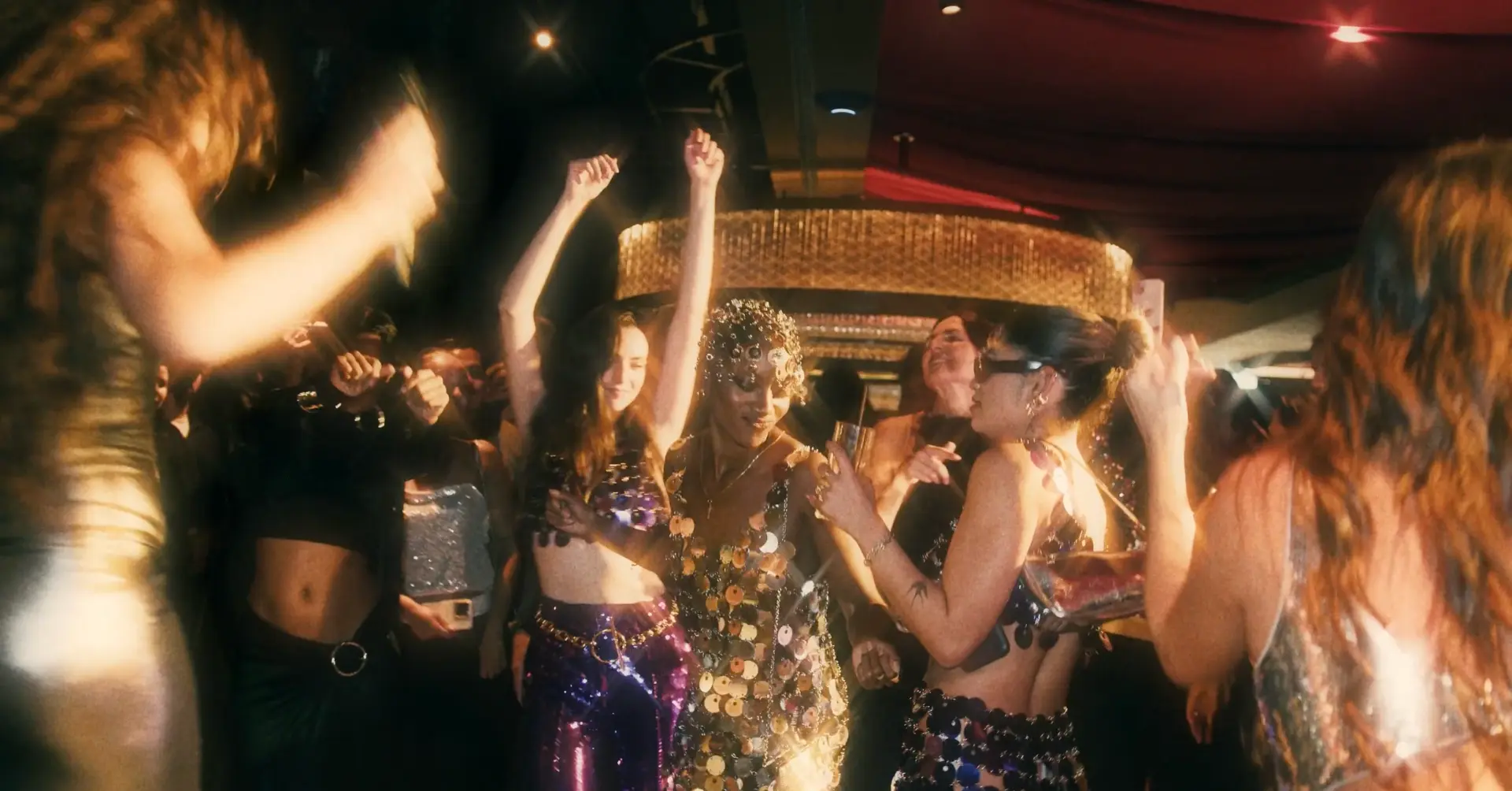 Guests dancing beneath warm chandeliers at the event