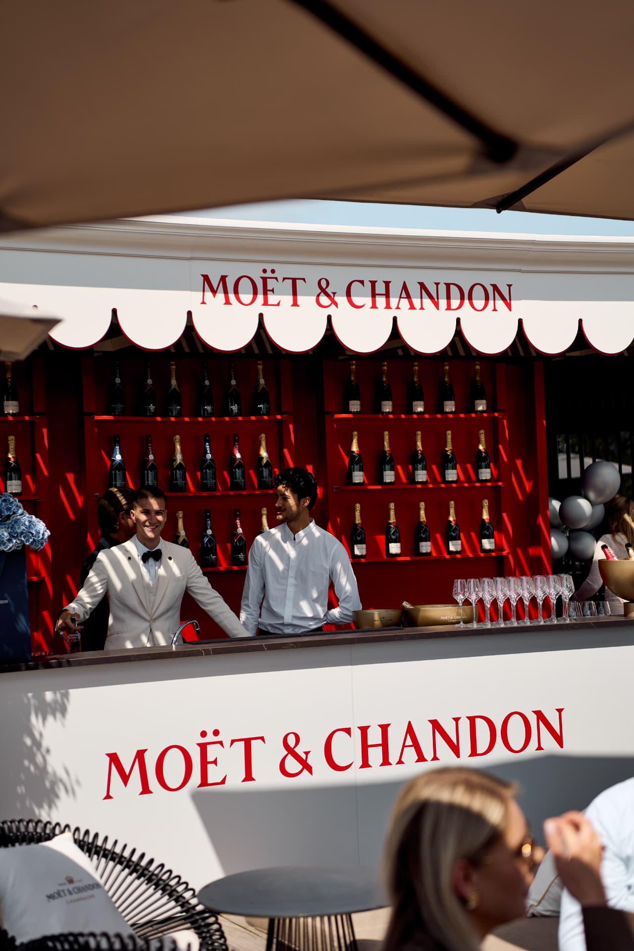 Bar staff behind the Moët & Chandon kiosk