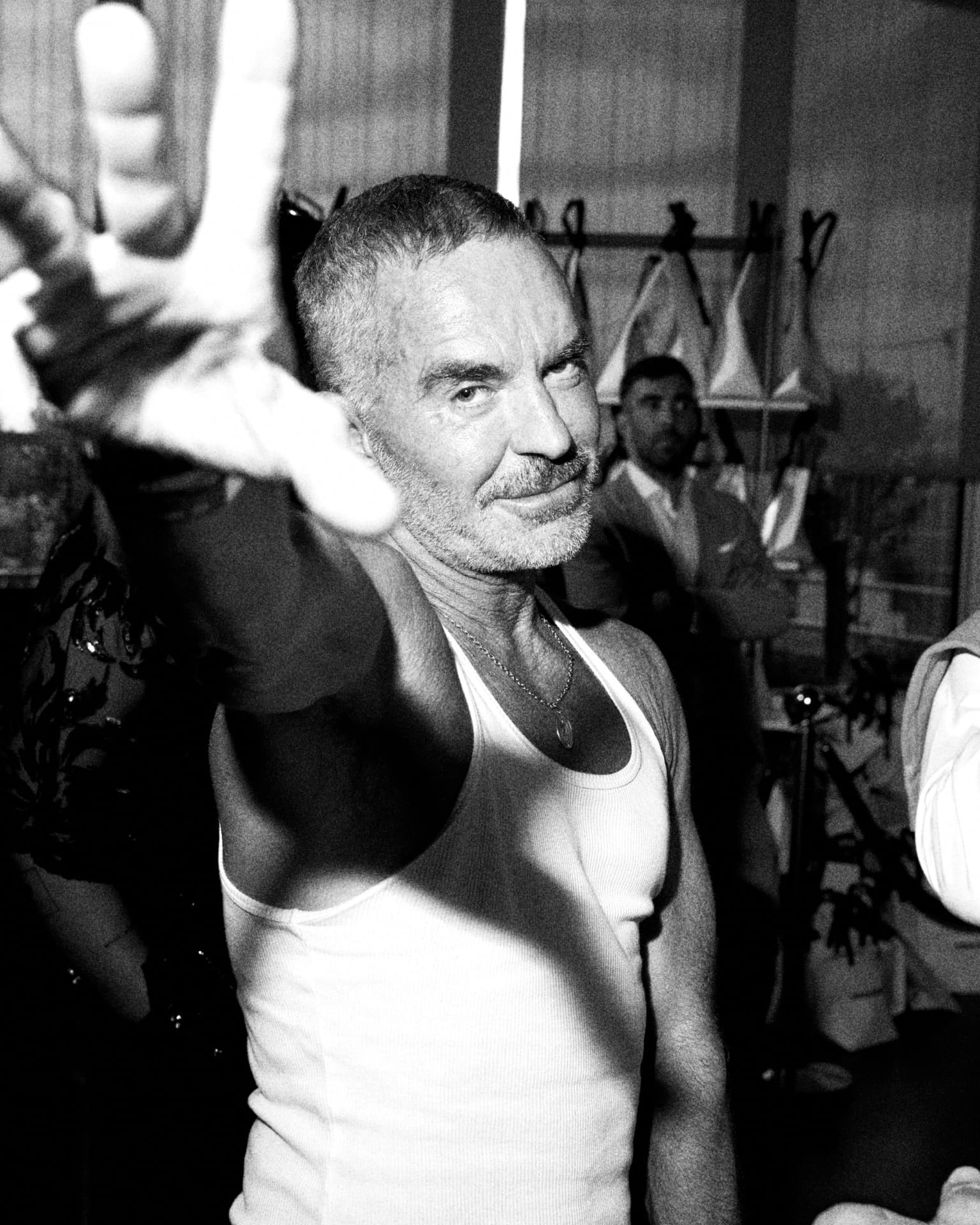 Dan Caten throwing a peace sign in a white tank, black and white