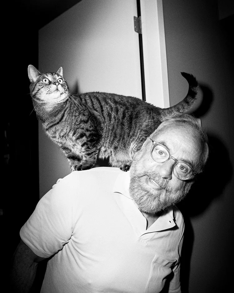 Man with a cat standing on his shoulder, black and white