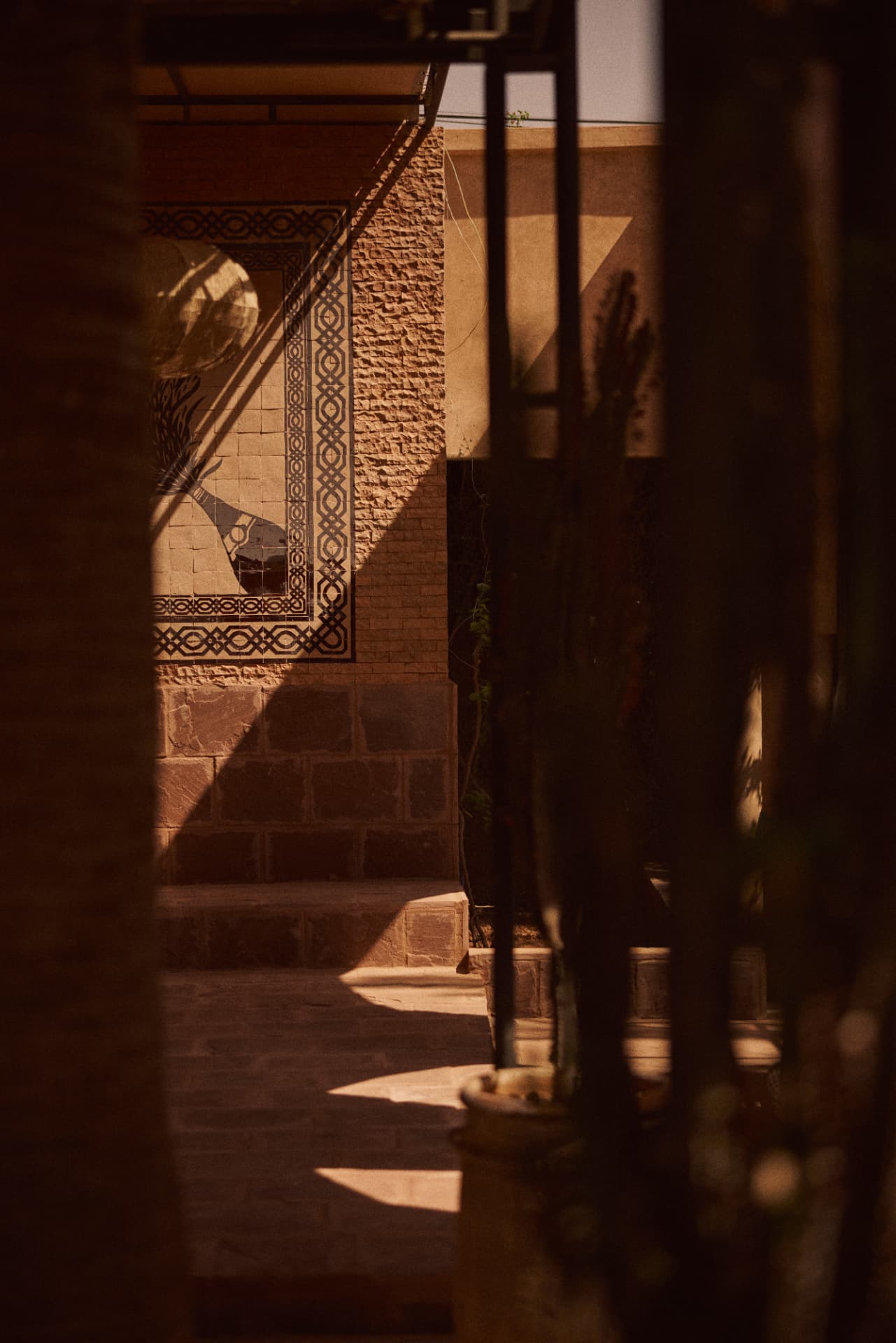 Carved stucco and a tiled urn panel in the riad courtyard