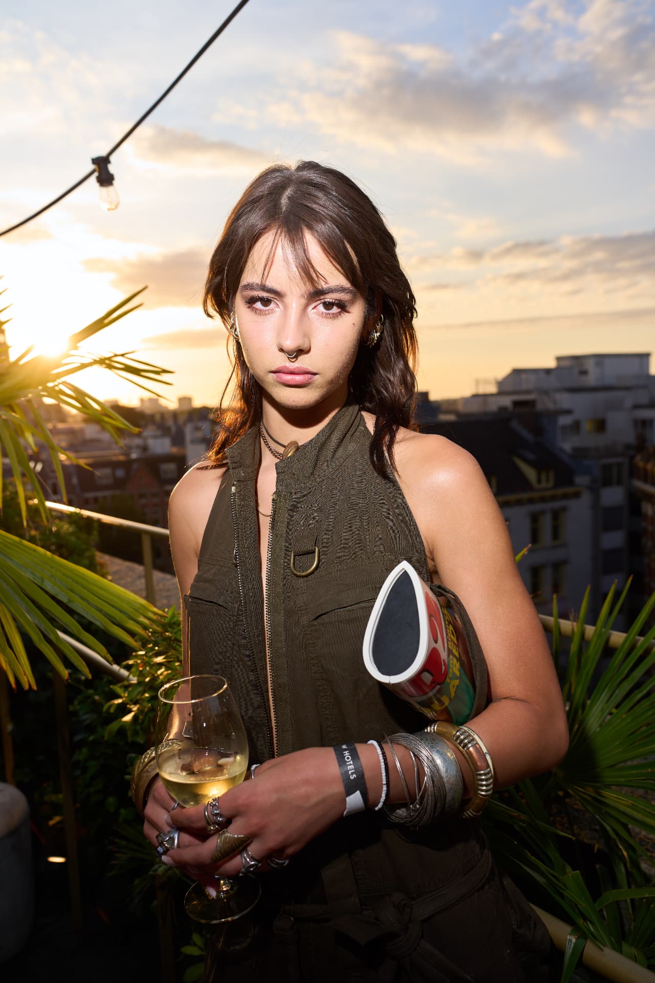 Guest on the rooftop at sunset holding a glass of wine