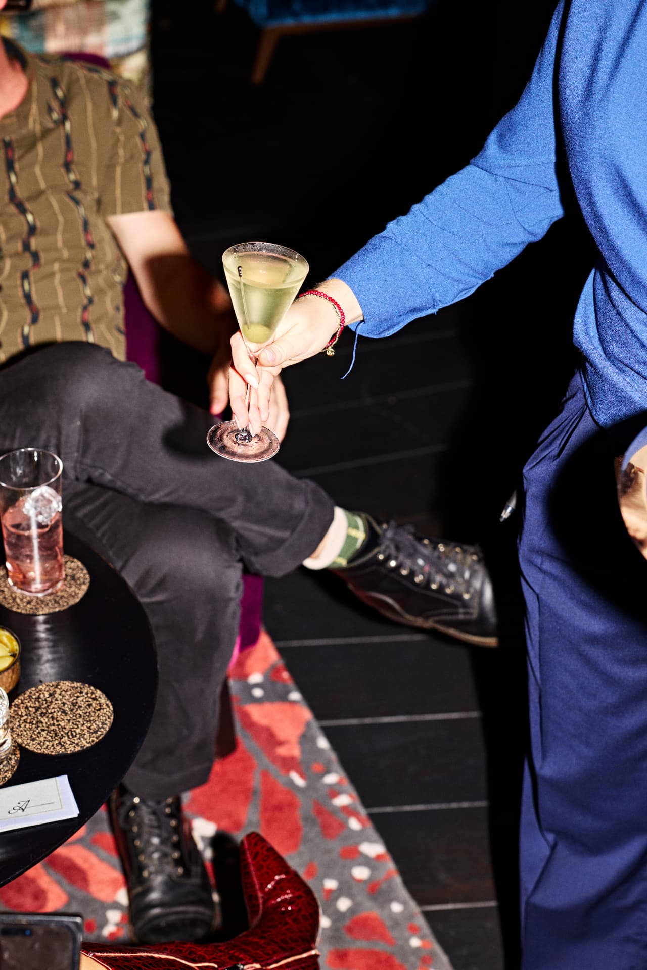 Guests holding cocktails around a lounge table