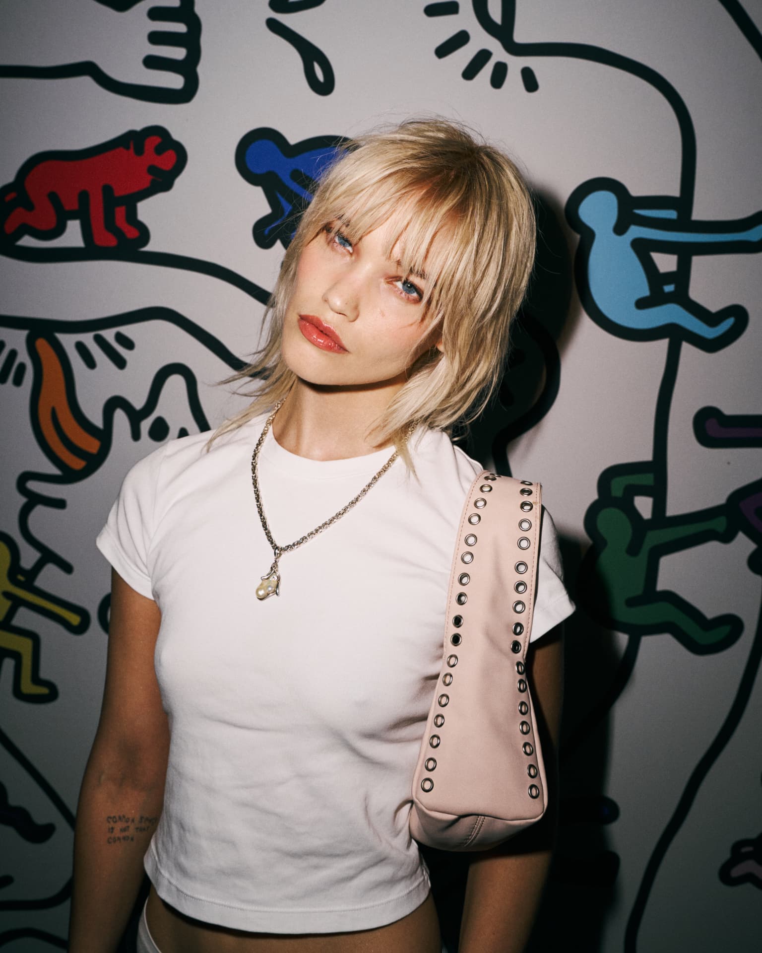 Guest in a white tee against the Keith Haring wall