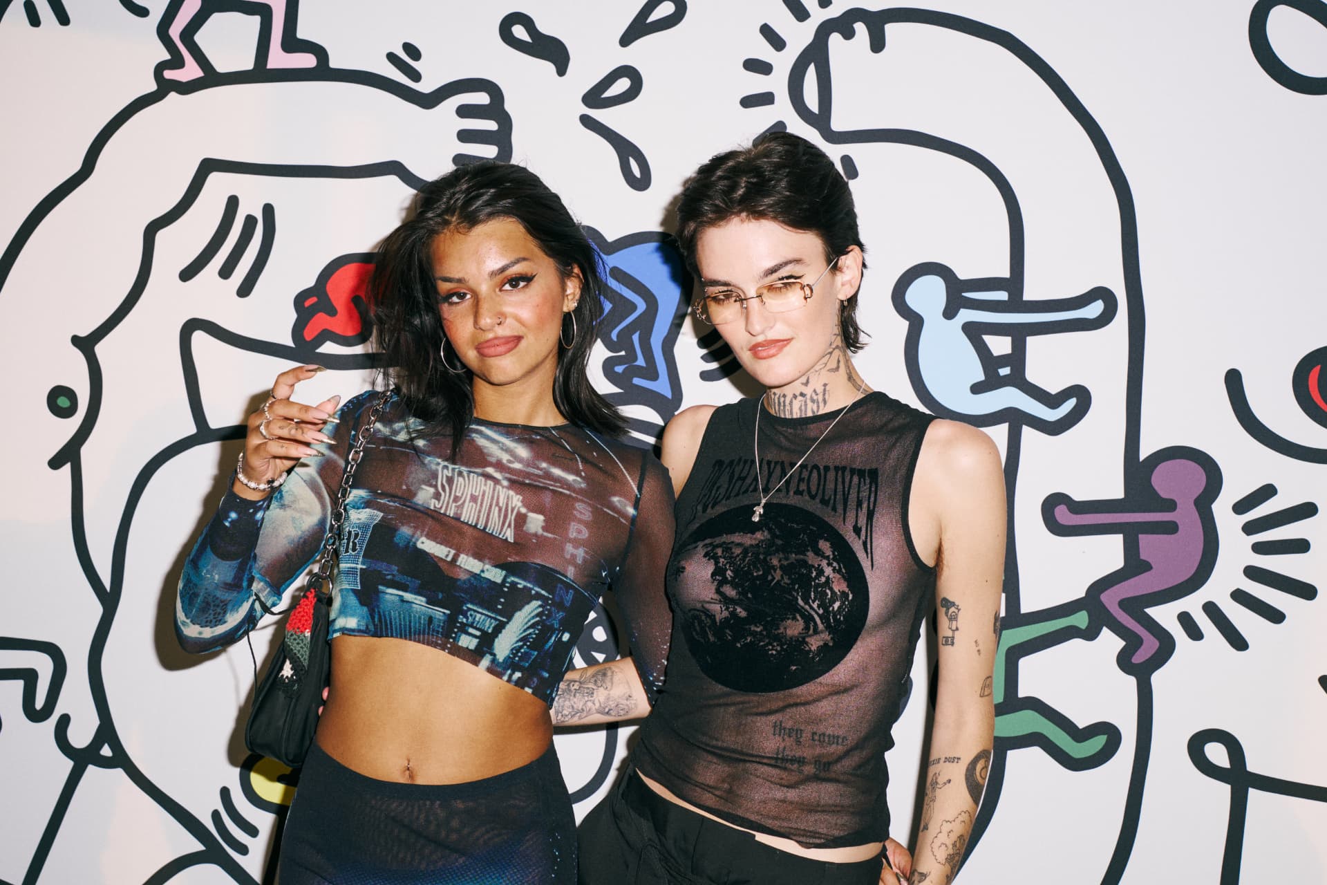 Two guests posing in front of the Haring artwork