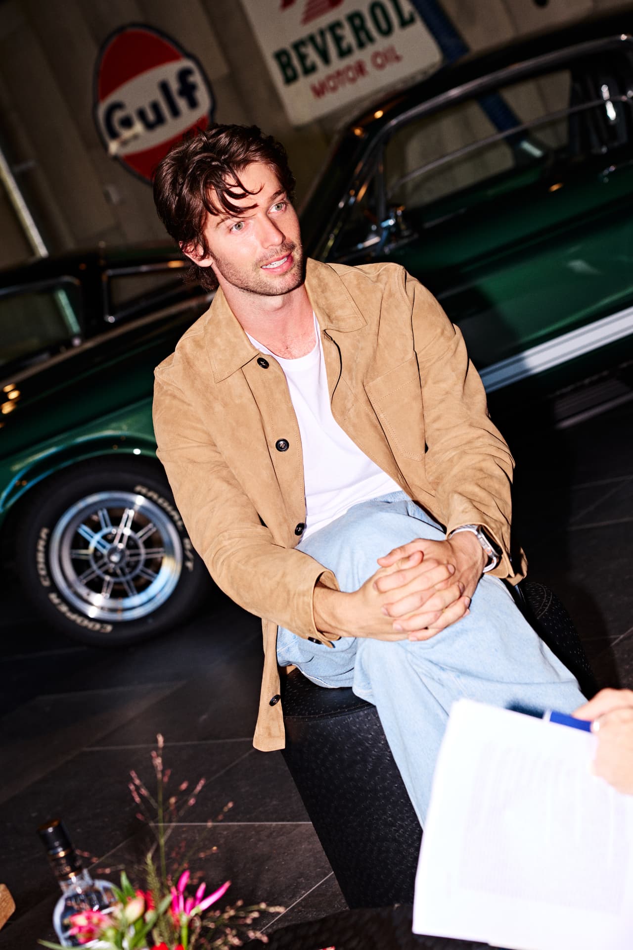 Guest seated beside a classic car